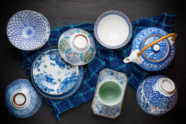 Ceramic utensils, bowl plate and teapot on table. Top view