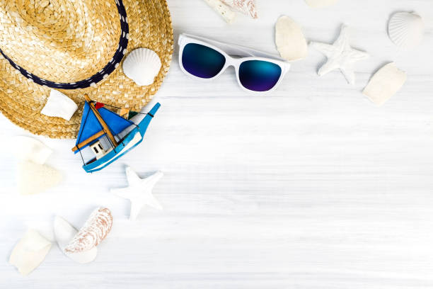 istock Summer Beach accessories (White sunglasses,starfish,straw hat,shell) on white plaster wood table top view,Summer vacation concept,Leave space for adding text 688321860