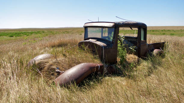 istock Vintage car in meadow with grass growing in it 688331934