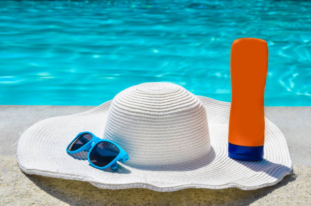 istock Summer hat, sunglasses and sunscreen near the pool 688335502
