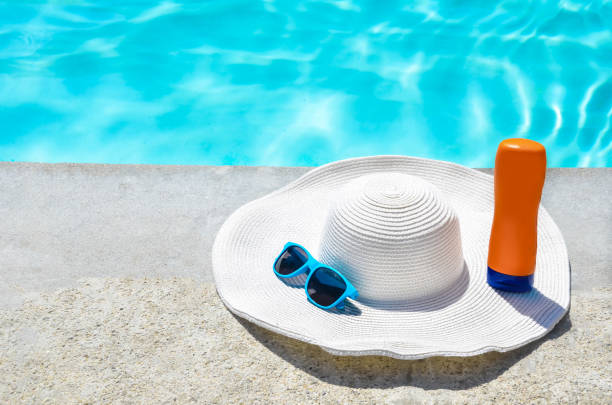 istock Summer hat, sunglasses and sunscreen near the pool 688337536