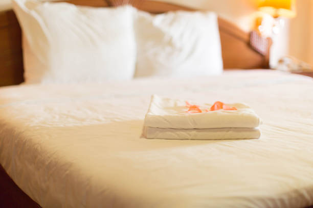 istock Hotel Room with a stack of towels with rose petals 688337578