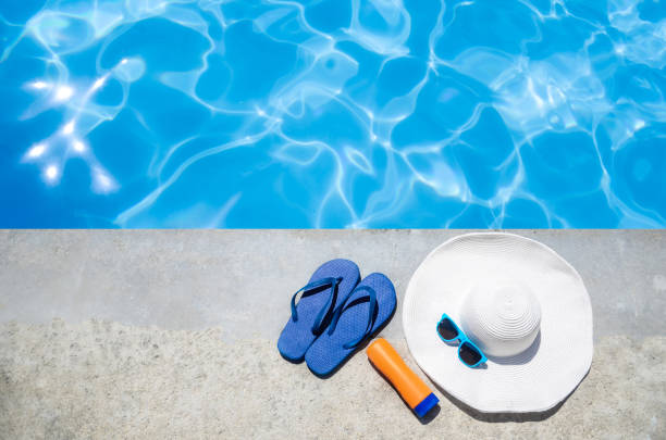 istock Summer background with hat, flip flops and sunglasses near the pool 688337692