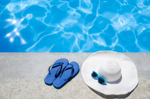 istock Summer background with hat, flip flops and sunglasses near the pool 688337698