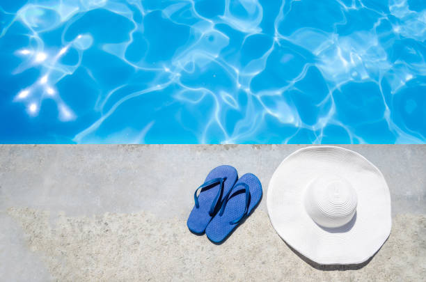 istock Summer background with hat, flip flops and sunglasses near the pool 688337738