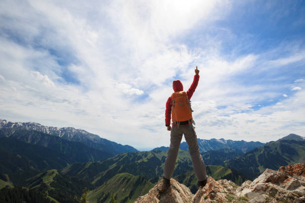 istock successful woman backpacker  on mountain peak 688355264