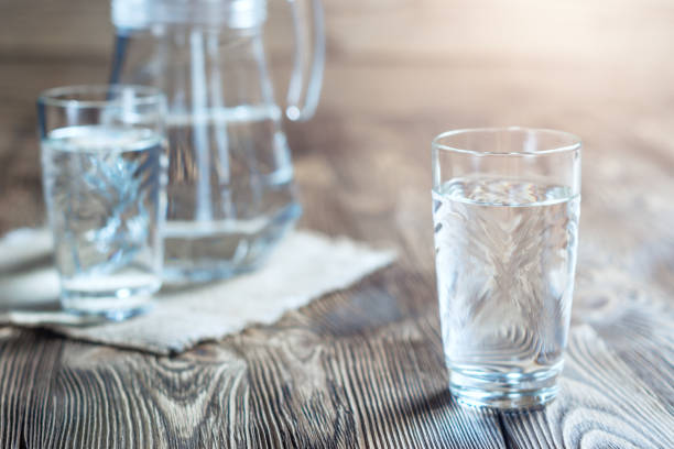 Glass of water on a wooden table. stock photo