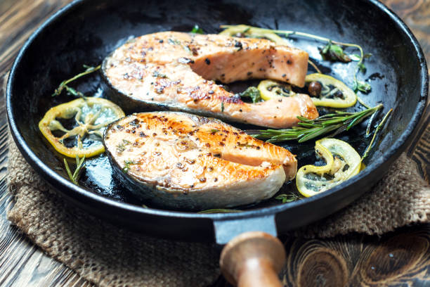 Salmon steak, fried with herbs, pepper and lemon stock photo