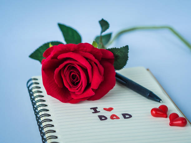 istock Father's day concept. I LOVE DAD message write on note book with red rose and pen on white background 688376786