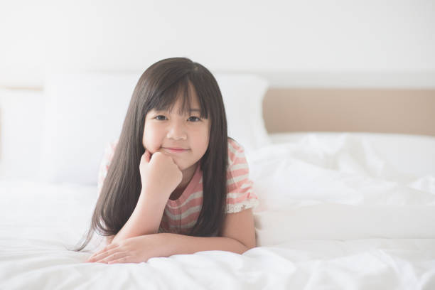 istock Happy asian girl lying o 688393424