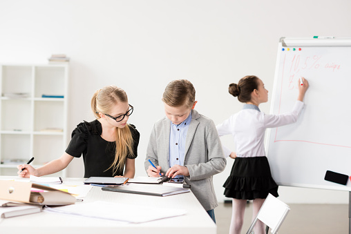Children working in office like adult business people