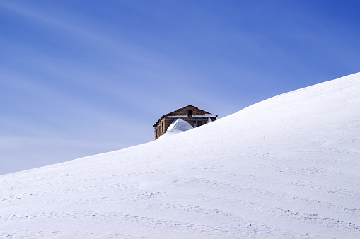 The old brick house covered with snow in middle of off-piste slope