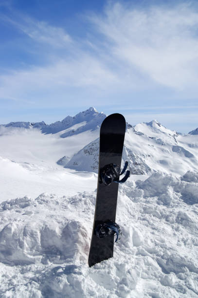 istock Snowboard against snowy mountains in sun day 688394628