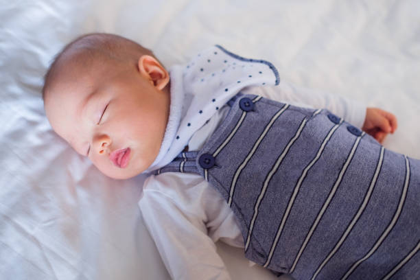 istock Peaceful baby lying on a bed while sleeping in a bright room 688398308