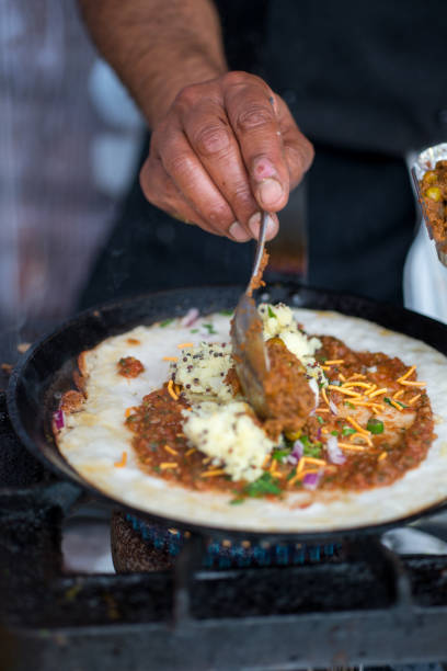 istock Hand adding fillings on dosa cooking on skillet 688403770