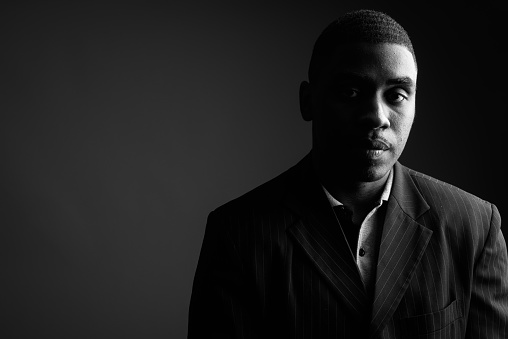 Studio shot of black serious young man wearing suit