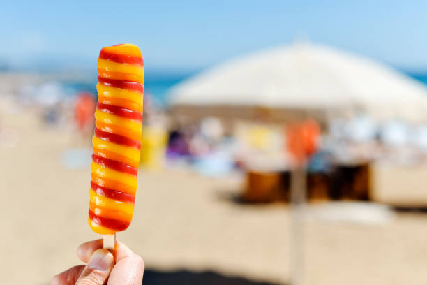 istock man eating a popsicle on the beach 688417824