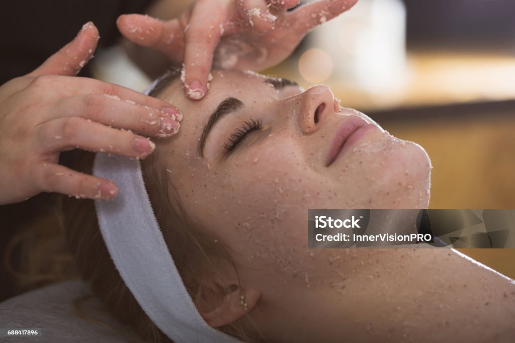 Jeune femme au cours du traitement de sel exfoliant visage - Photo de Visage libre de droits