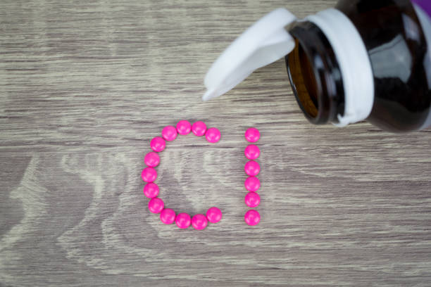 istock Pink pills forming shape to Cl alphabet on wood background 688420596