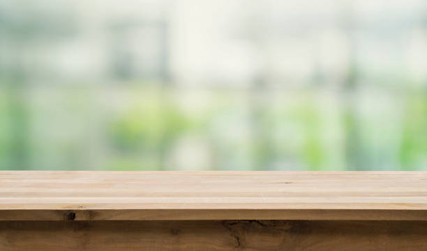 istock Wood table top on abstract window glass background. 688424002