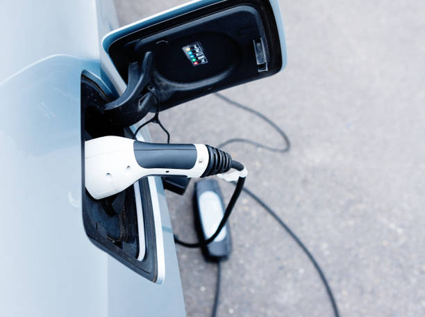 istock Electric car being charged, high angle view 688435354