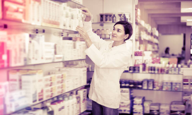 istock Pretty female pharmacist offering products 688444372