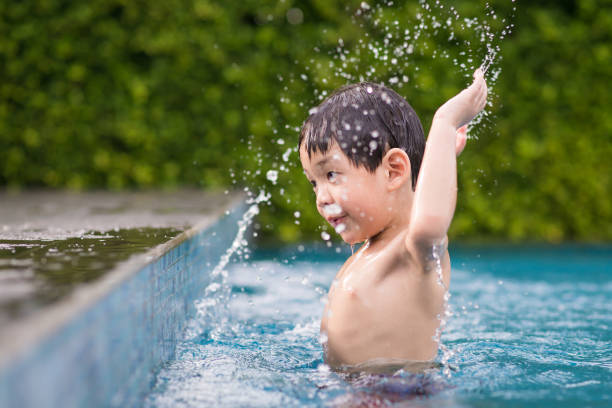 istock Asian child playing in swimming pool 688445292