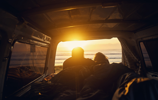 Rearview shot of a young couple relaxing inside their car during a roadtrip