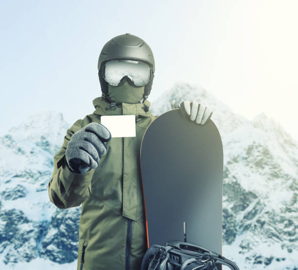 istock Young snowboarder holding blank lift pass with mountain on background. Filtered image:cross processed vintage effect. 688458712