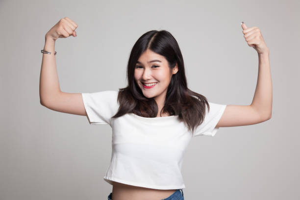 istock Beautiful young Asian woman flex bicep. 688460926