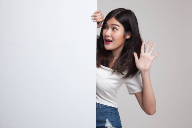 istock Excited young Asian woman with blank sign. 688468110