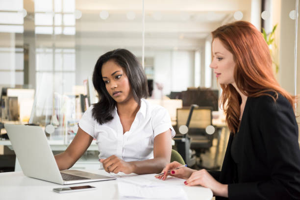 istock Two professional businesswomen using laptop in office 688468792