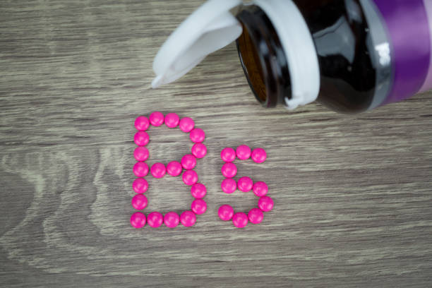 istock Pink pills forming shape to B5 alphabet on wood background 688472056