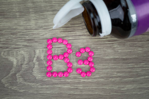 istock Pink pills forming shape to B3 alphabet on wood background 688475558