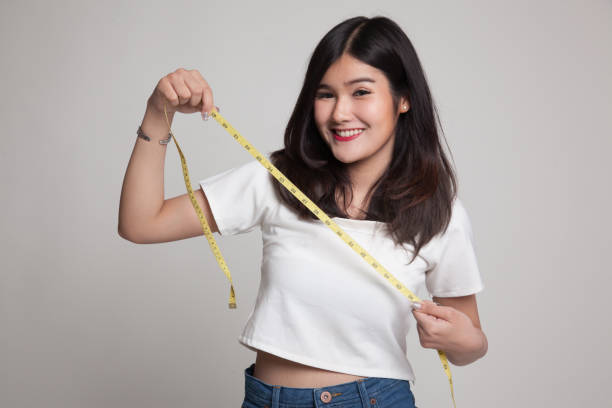 istock Young Asian woman with measuring tape. 688475720