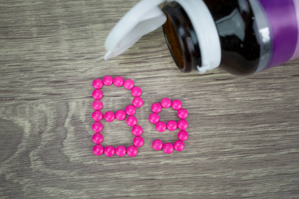 istock Pink pills forming shape to B9 alphabet on wood background 688476022