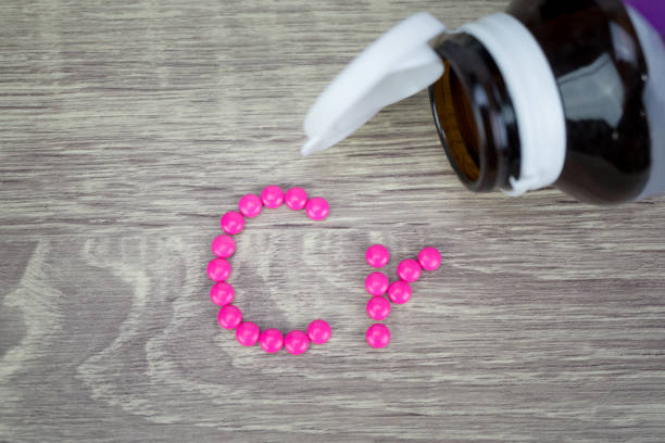 istock Pink pills forming shape to Cr alphabet on wood background 688476286