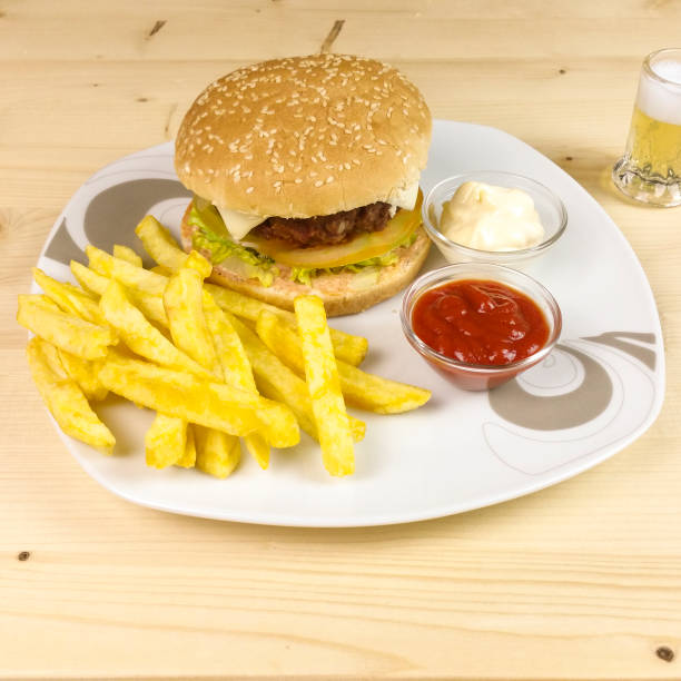istock Burger and chips on wooden background 688485330