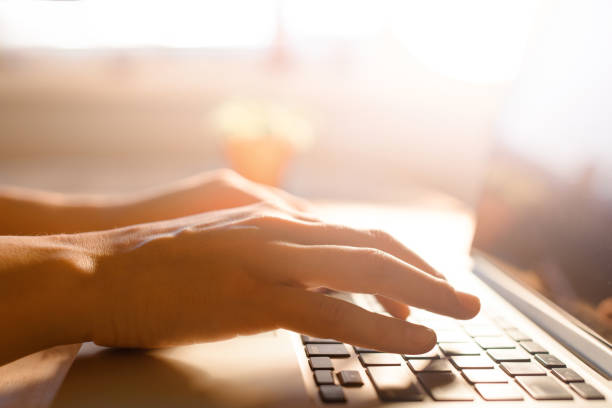 istock Hands working on the computer keyboard, pressing buttons, typing, simple close up with lens flare 688492220