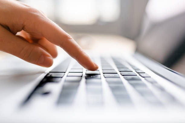 istock Single finger press button on laptop keyboard, close up clean image with sun flare 688492236