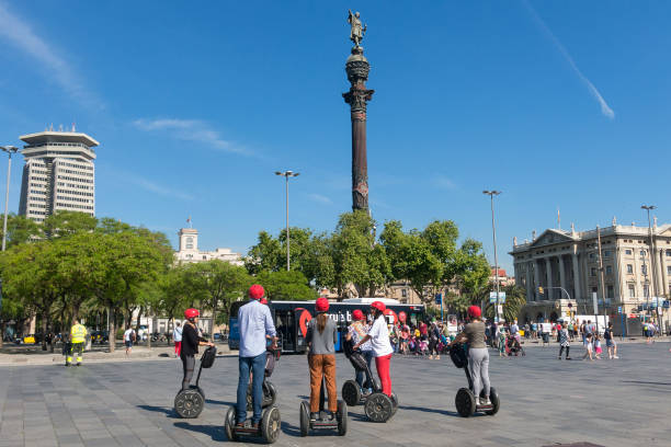 pomnik krzysztofa kolumba wskazujący amerykę, turyści podróżują segwayem. barcelona, hiszpania - segway zdjęcia i obrazy z banku zdjęć