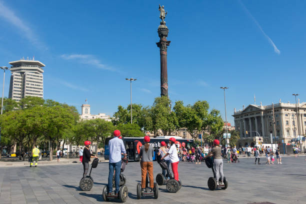 estátua de christopher columbus apontando américa, touristst viajar de segway. barcelona, espanha - segway - fotografias e filmes do acervo