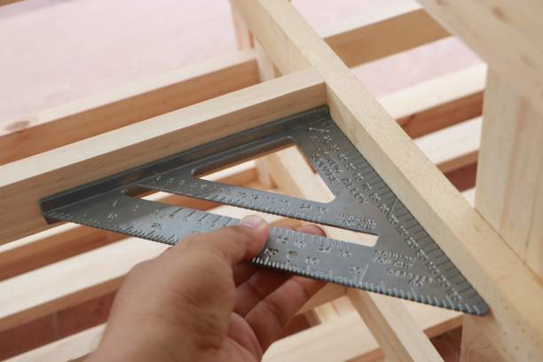 Hand of carpenter is measuring angle of wooden furniture stock photo
