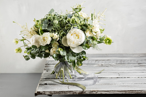 Ramo de novia vintage. De la novia. Hermosa de flores y verdor, decorado con cinta de seda, se encuentra en mesa de madera vintage. estilo vintage photo