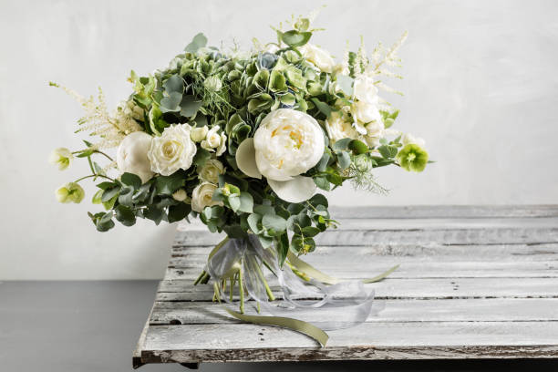 ビンテージ ブーケ。花嫁の。混合花と緑、絹のリボンで飾られたヴィンテージの木製テーブルの上にある美しい。ビンテージ スタイル - ブーケ ストックフォトと画像