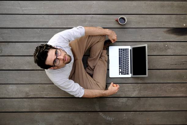 istock Young adult man using laptop during coffee break 688499756