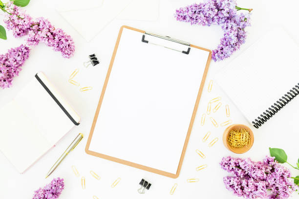 istock Minimalistic workspace with clipboard, notebook, pen, lilac and accessories on white background. Flat lay, top view. Beauty blog concept 688509652