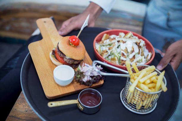 Server holding fast food platter at a cafe