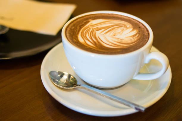 istock cup of coffee with heart pattern in a white cup on wooden background 688512204