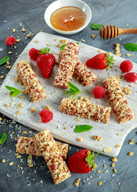 istock Granola bar with strawberries, raspberry honey and white chocolate on cutting board 688512314